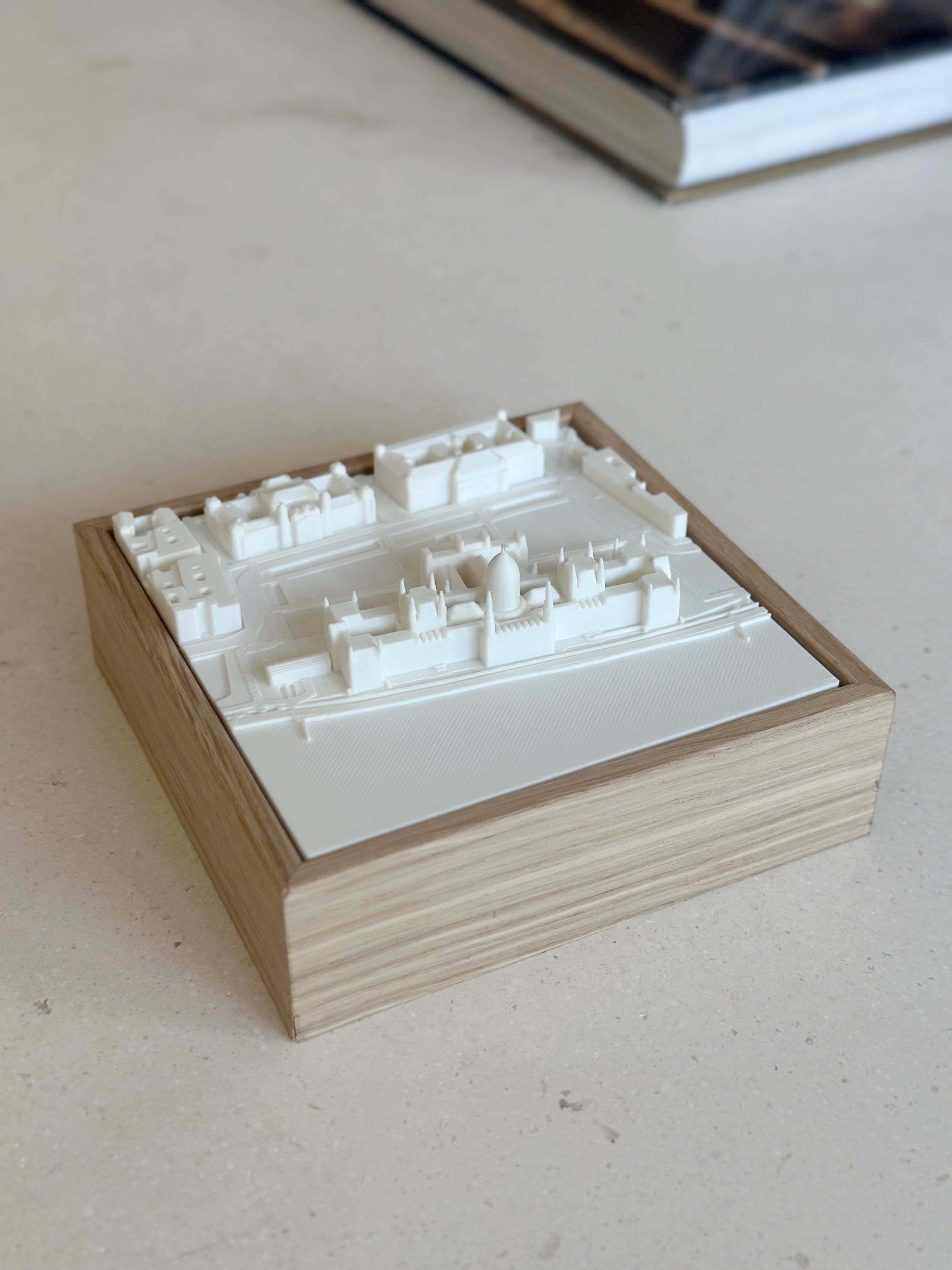 3D city map wall art in white with wooden frame on a light surface