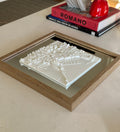 3D city map wall art in wooden frame on table, modern home decor near stacked books.