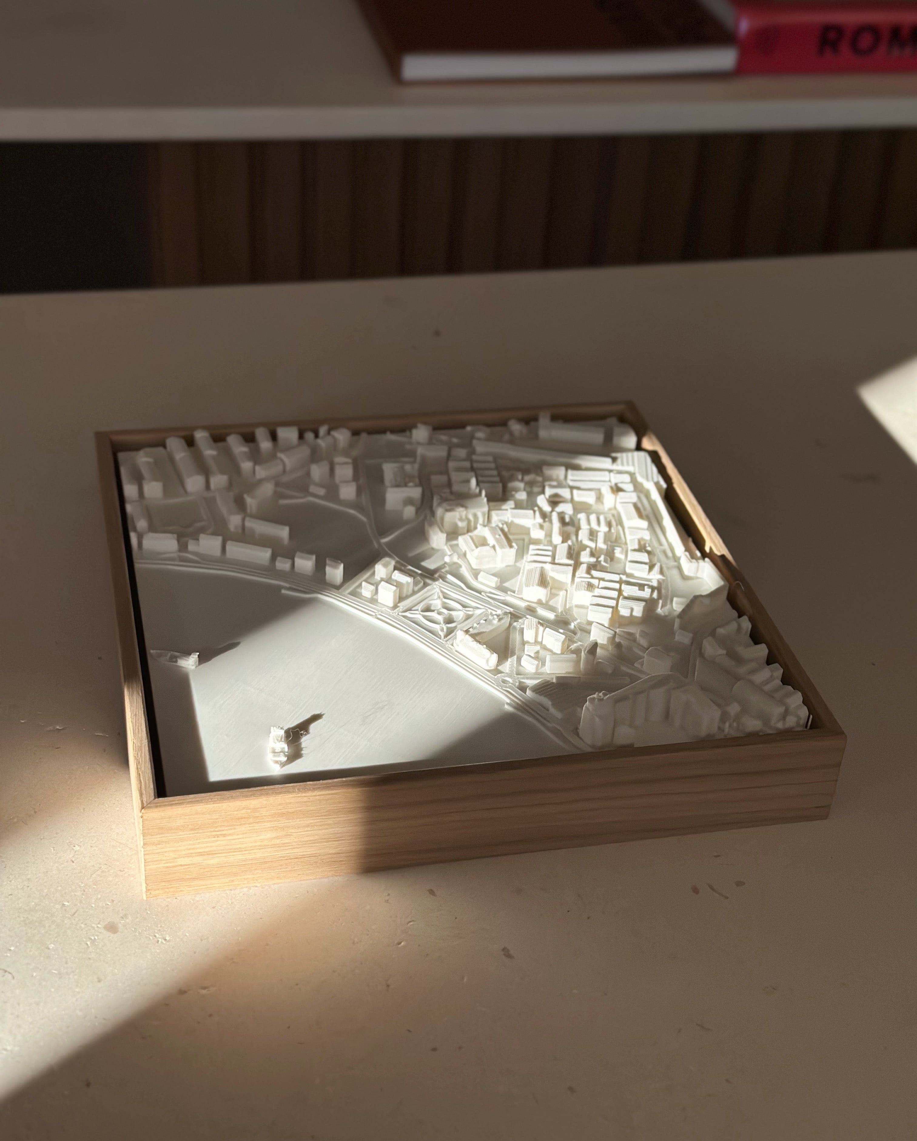 3D city map wall art in a wooden frame, detailed urban decor piece on a table
