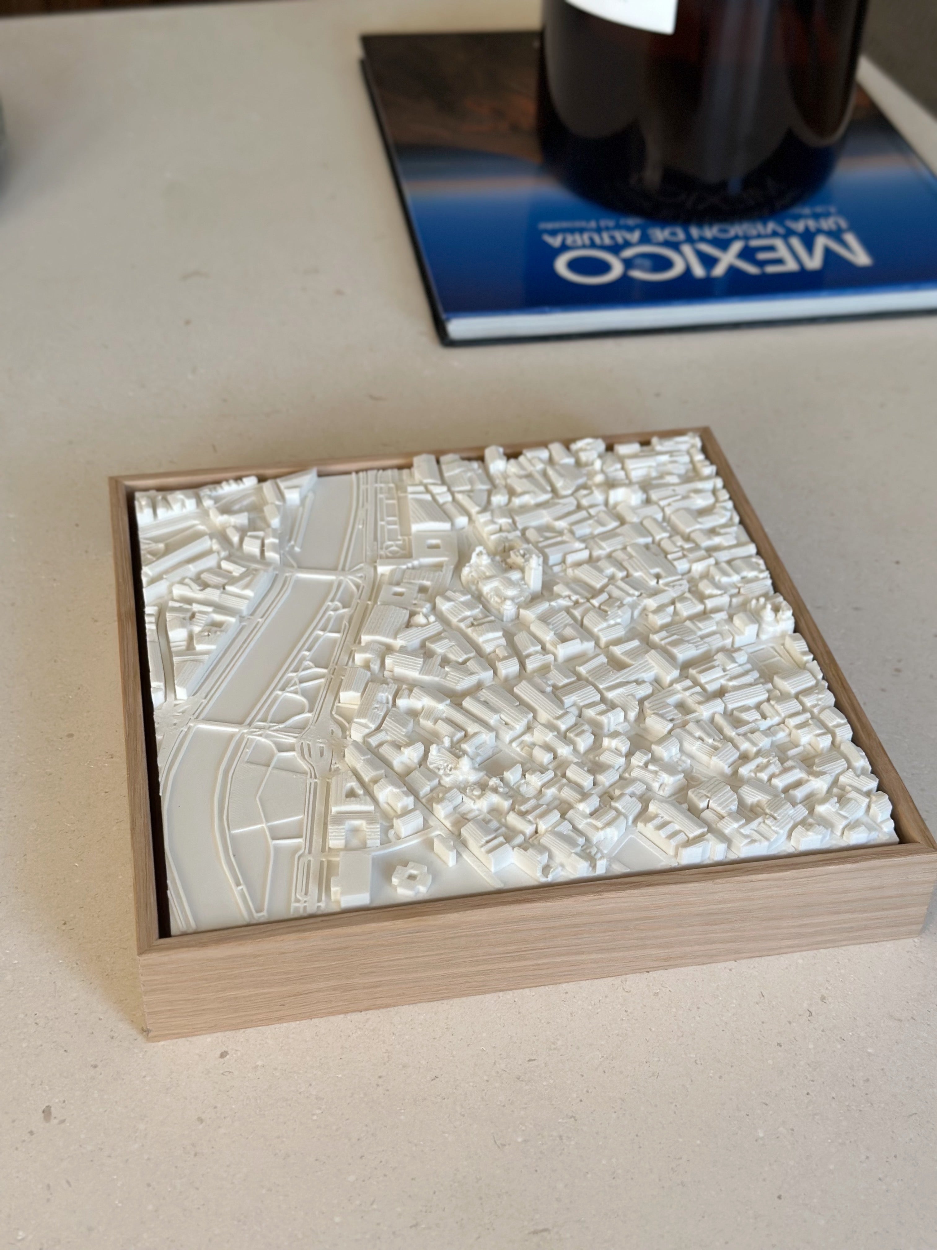 3D city map wall art in a wooden frame, white urban landscape decor on a table