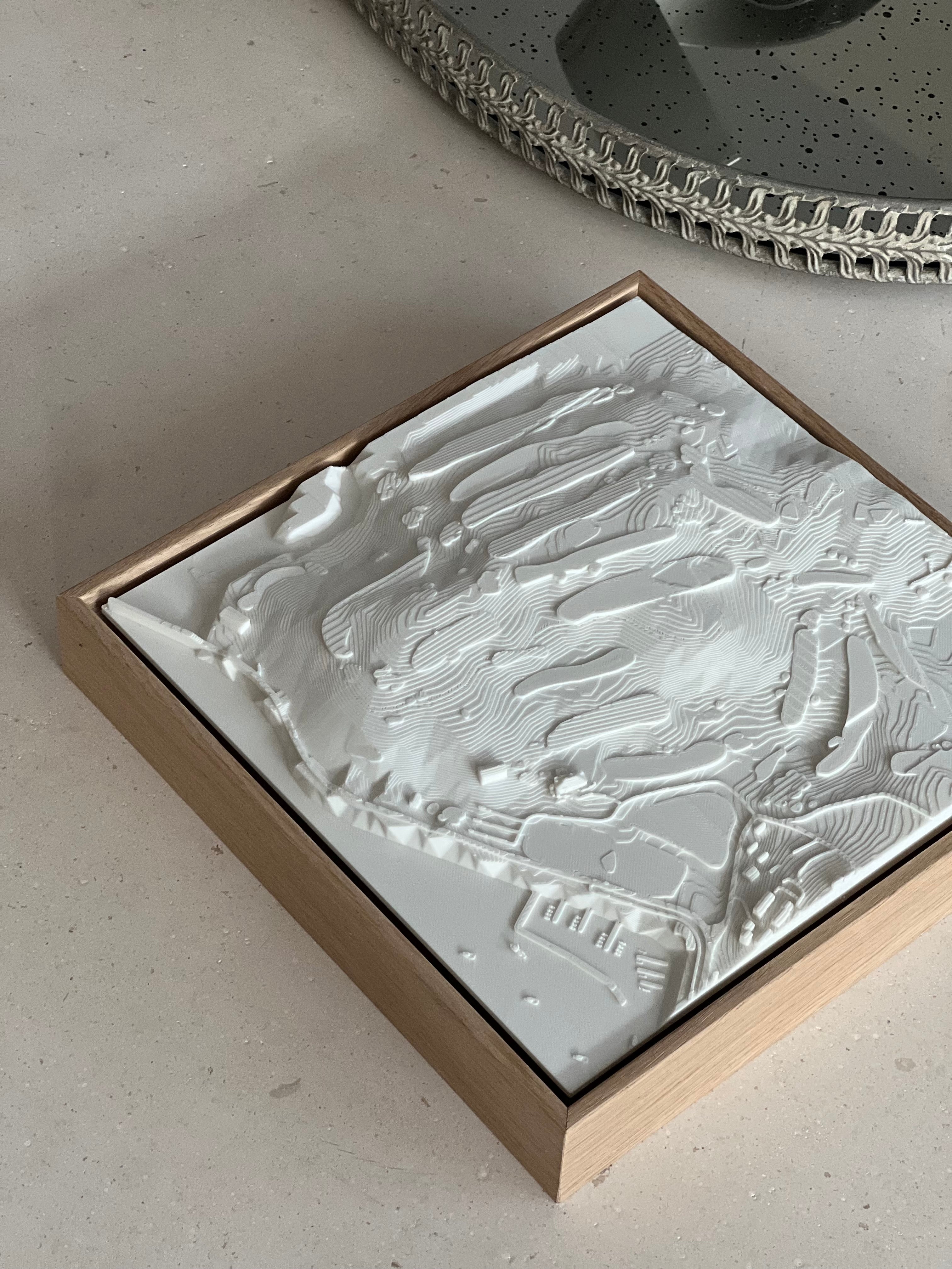 3D city map wall art in a wooden frame on a stone surface, modern decorative piece