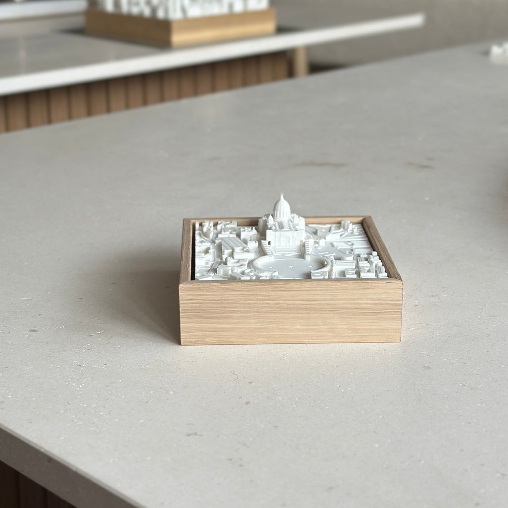 3D city map wall art in a wooden frame featuring detailed white architectural structures