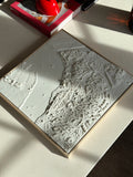 3D city map wall art in white, showing detailed streets and buildings on a minimalist table