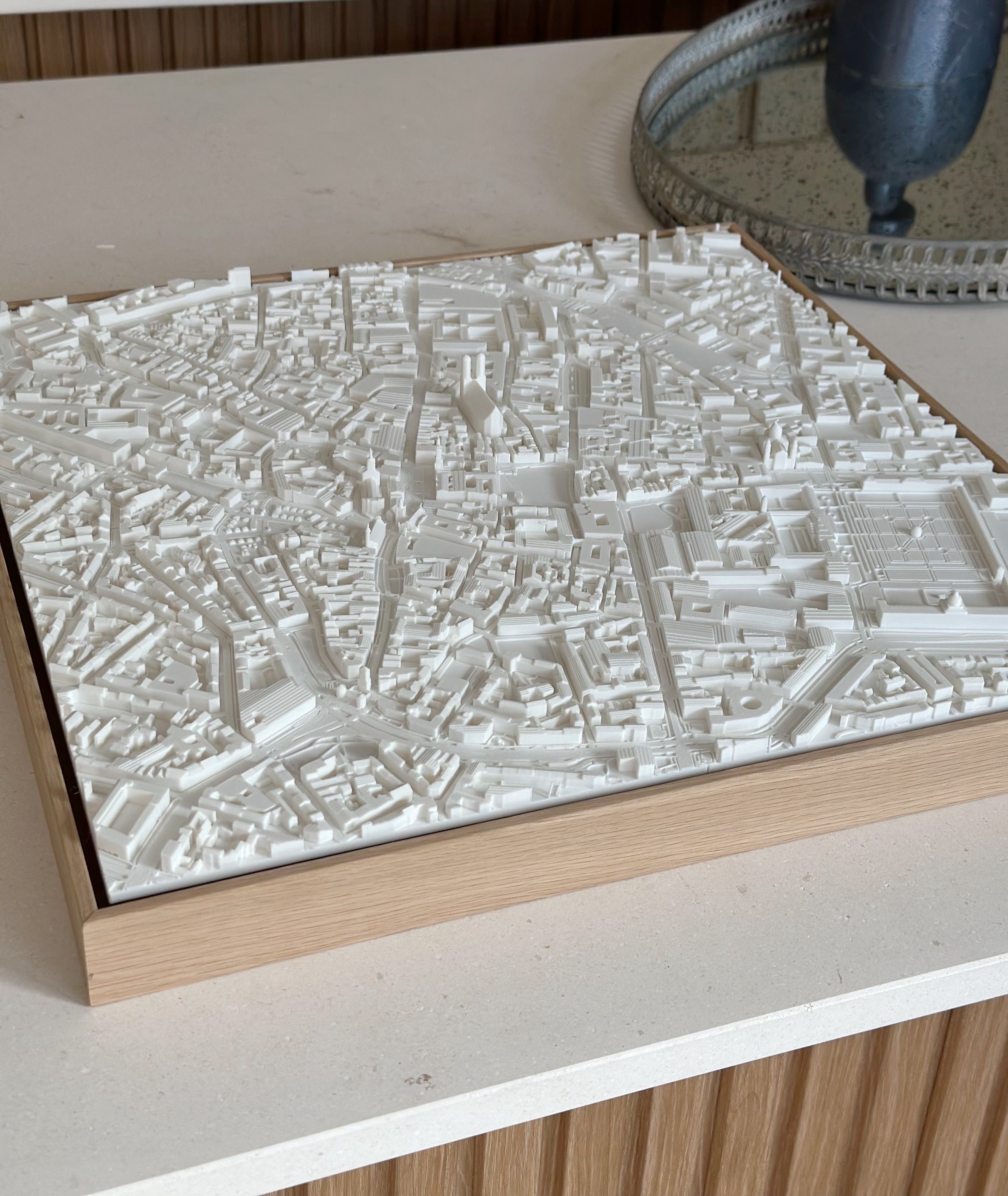 3D city map wall art in a wooden frame on a modern tabletop, urban decor piece