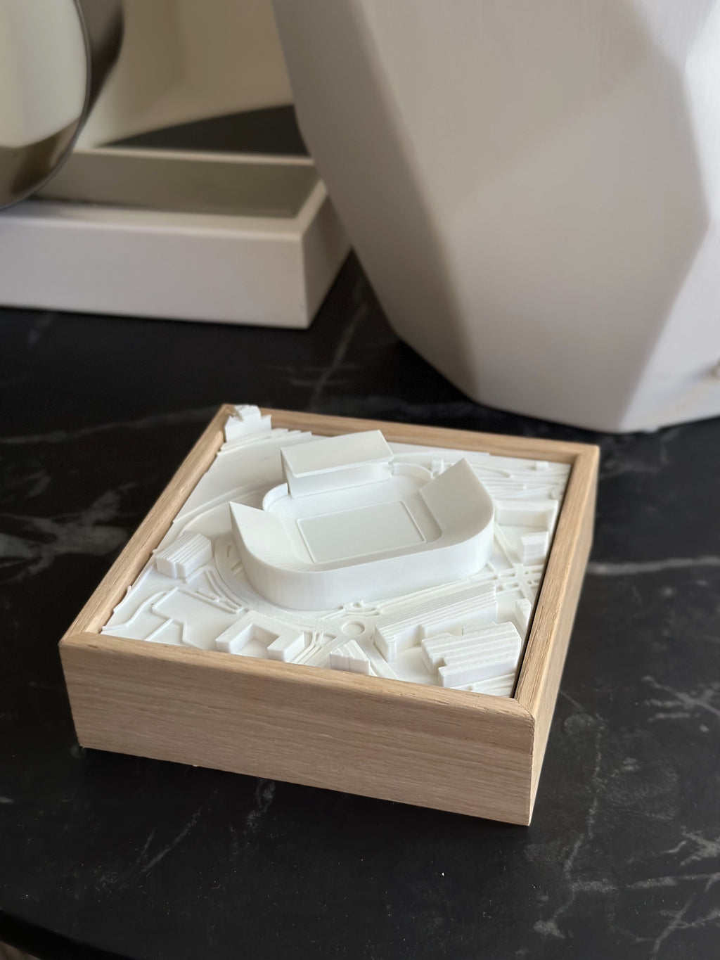 3D city map art in wooden frame, architectural model for home decor on dark surface