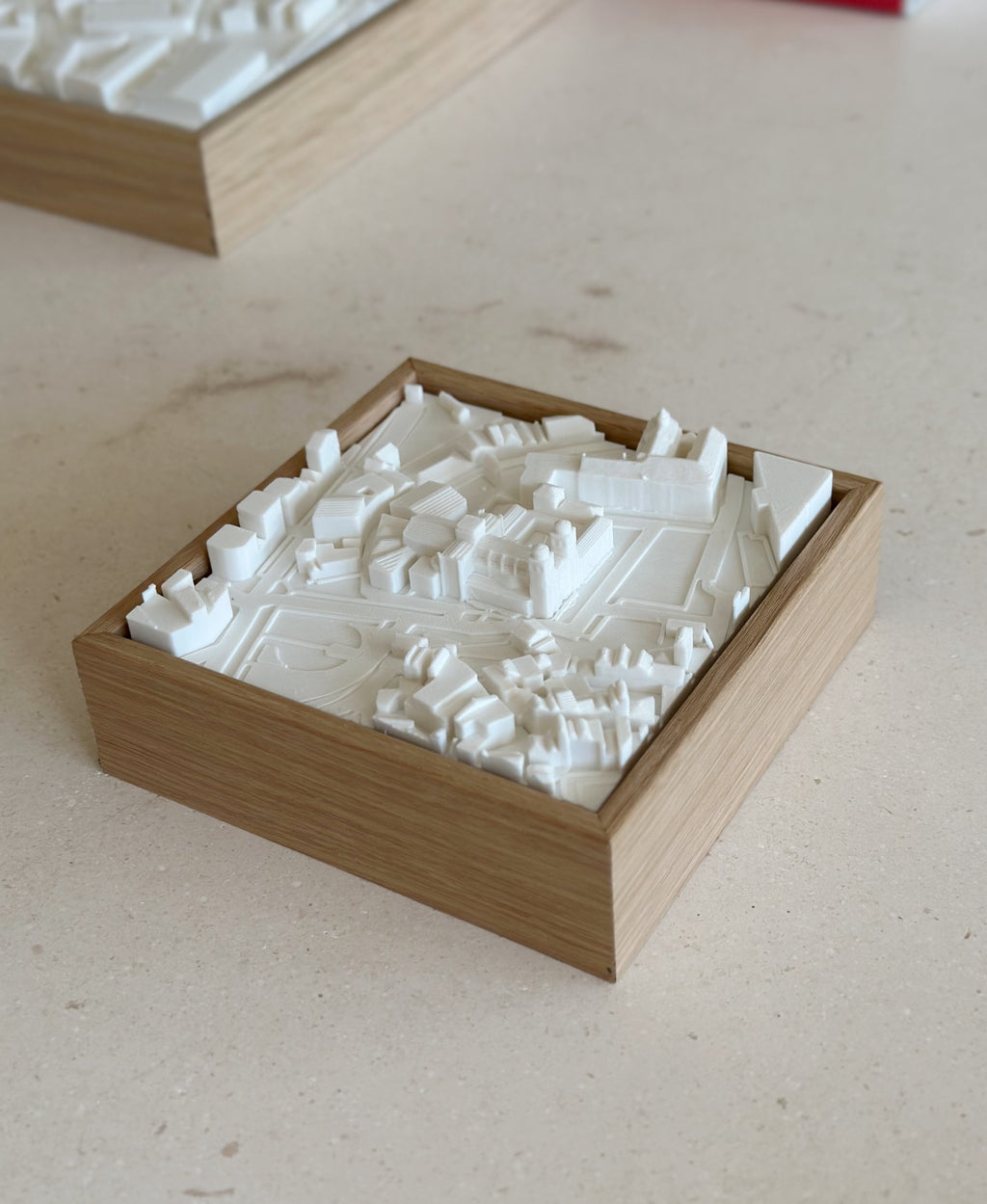 3D city map wall art in a wooden frame on a beige surface, modern home decor