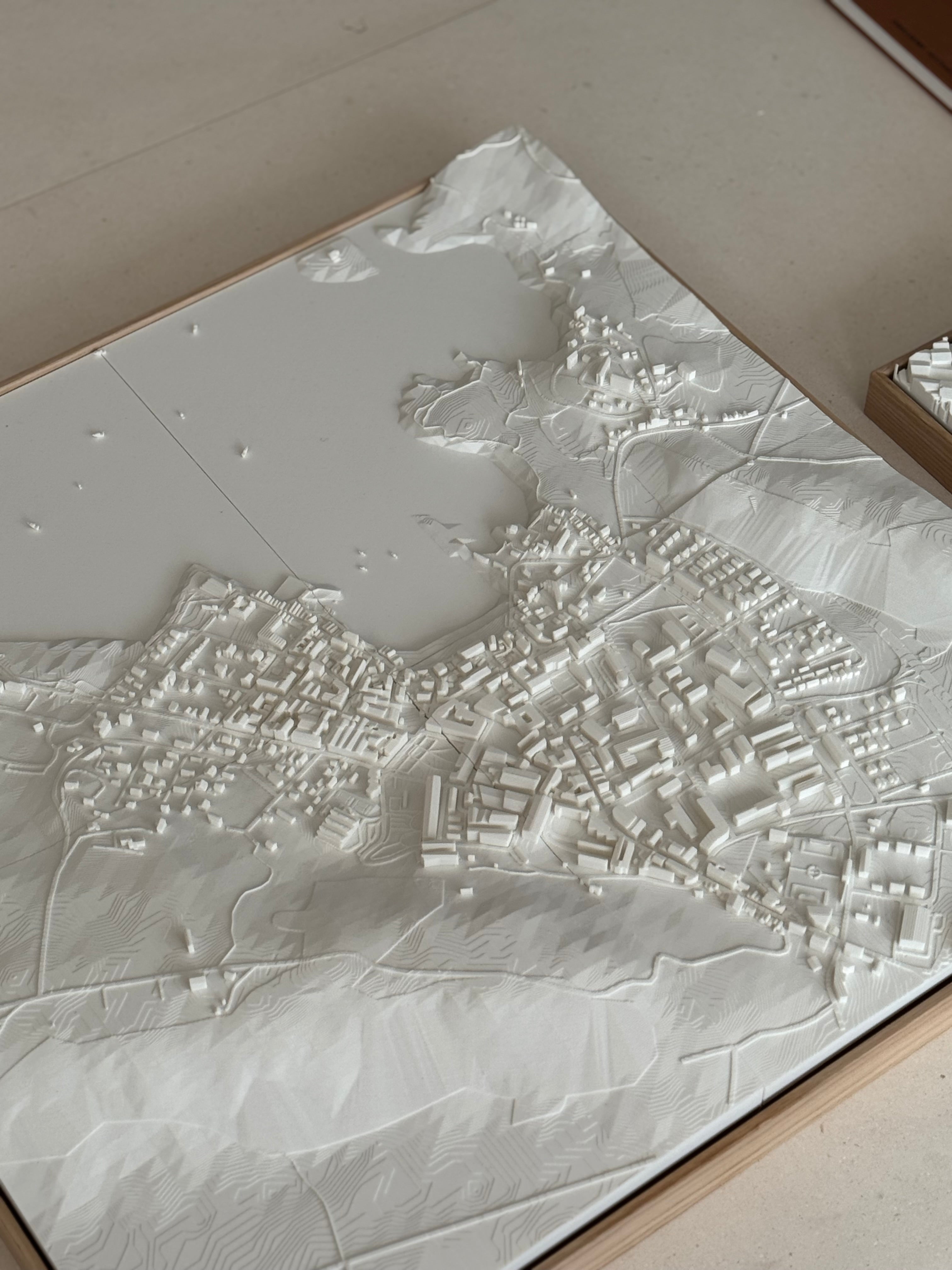 3D city map wall art with detailed white topographic buildings and landscape