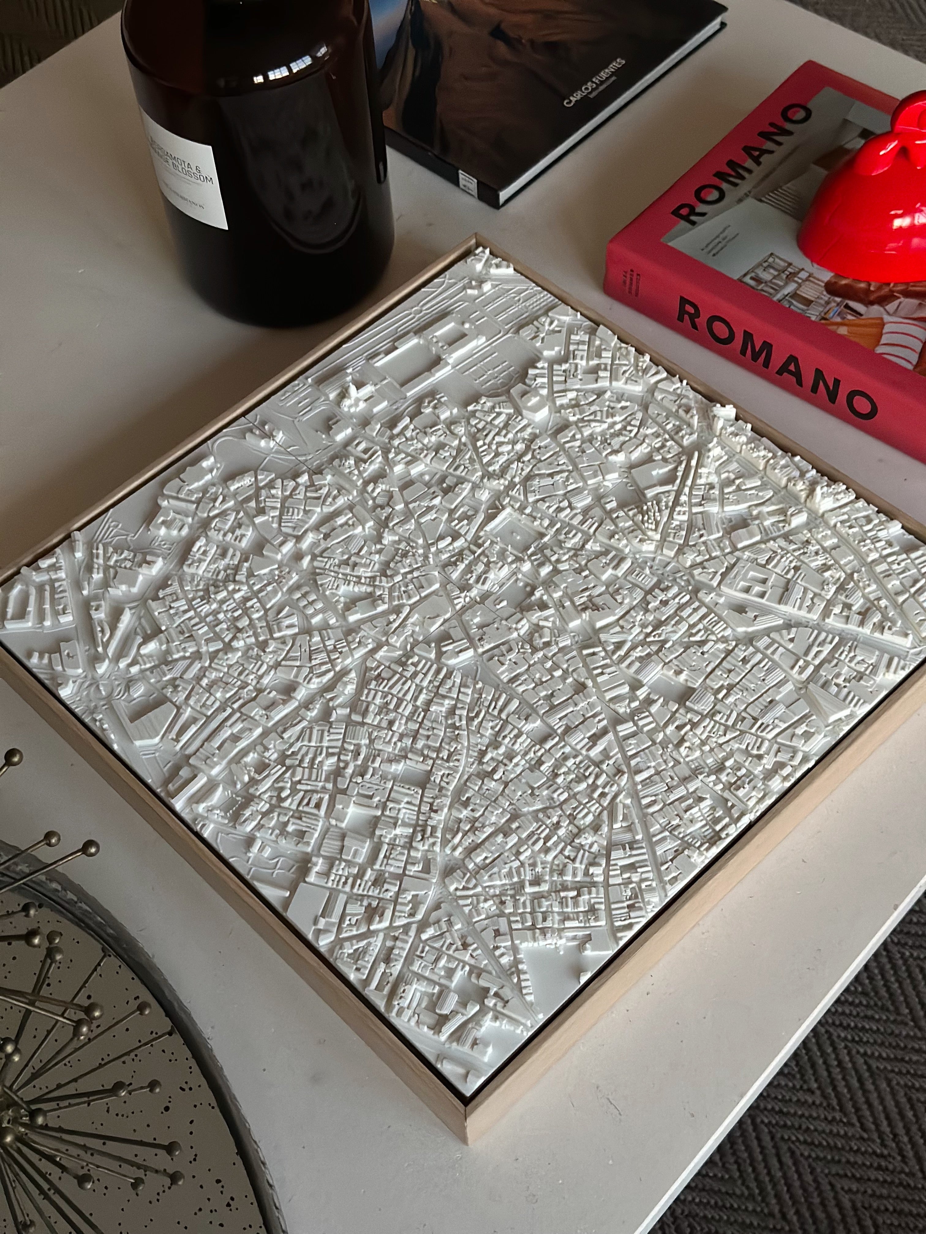 3D city map wall art in white on a modern coffee table with books and decor