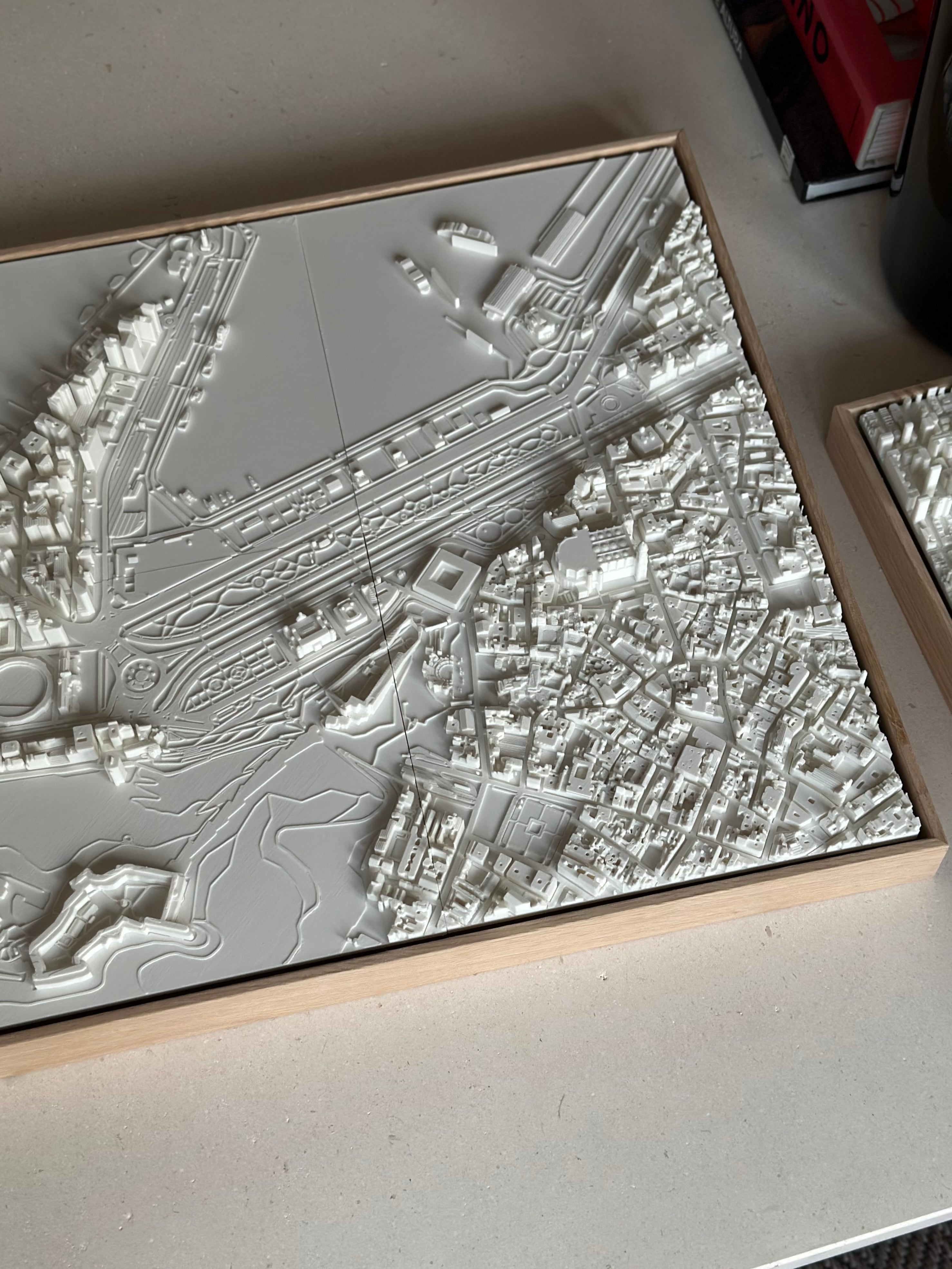 3D city map wall art in a wooden frame, showcasing intricate urban landscape details.