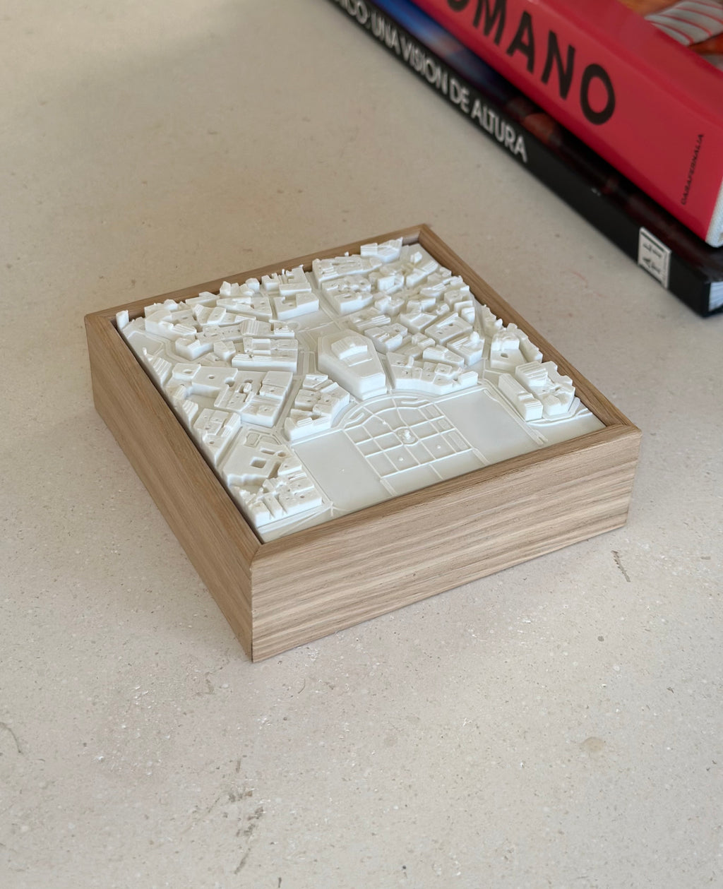 3D city map wall art in a wooden frame on a light table, modern home decor piece.