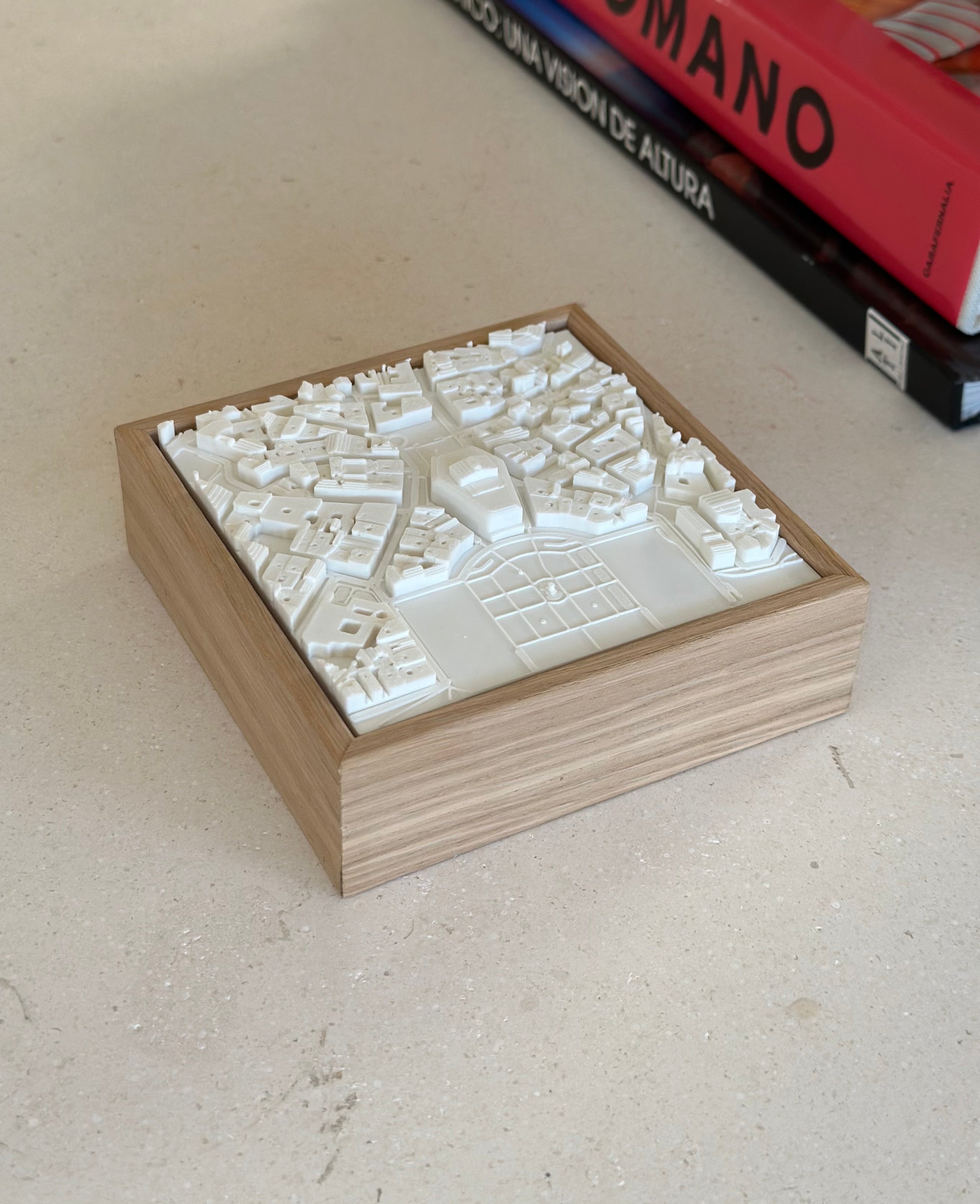 3D city map wall art in a wooden frame on a light table, modern home decor piece.