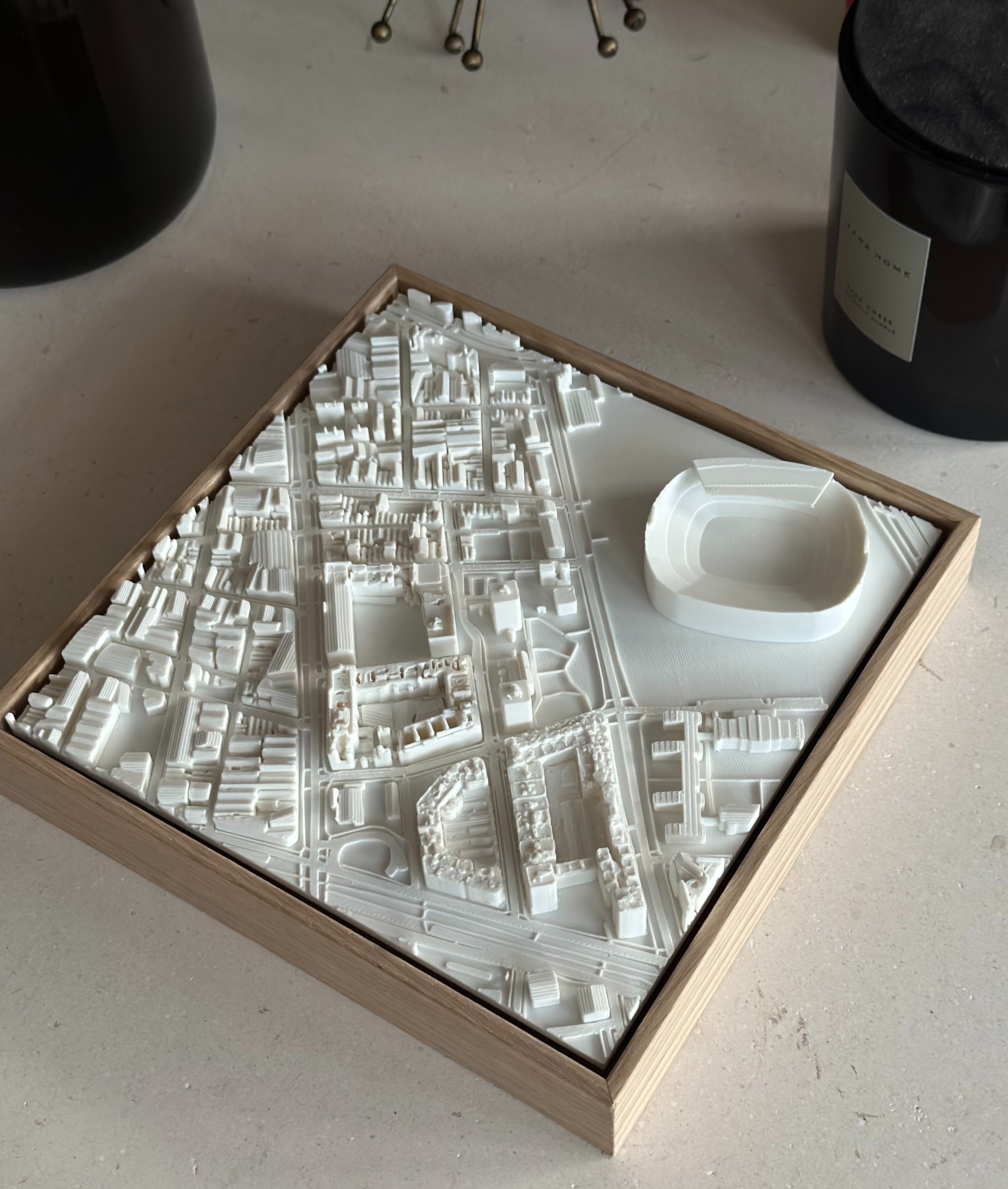 3D city map wall art in a wooden frame showing detailed streets and a stadium model