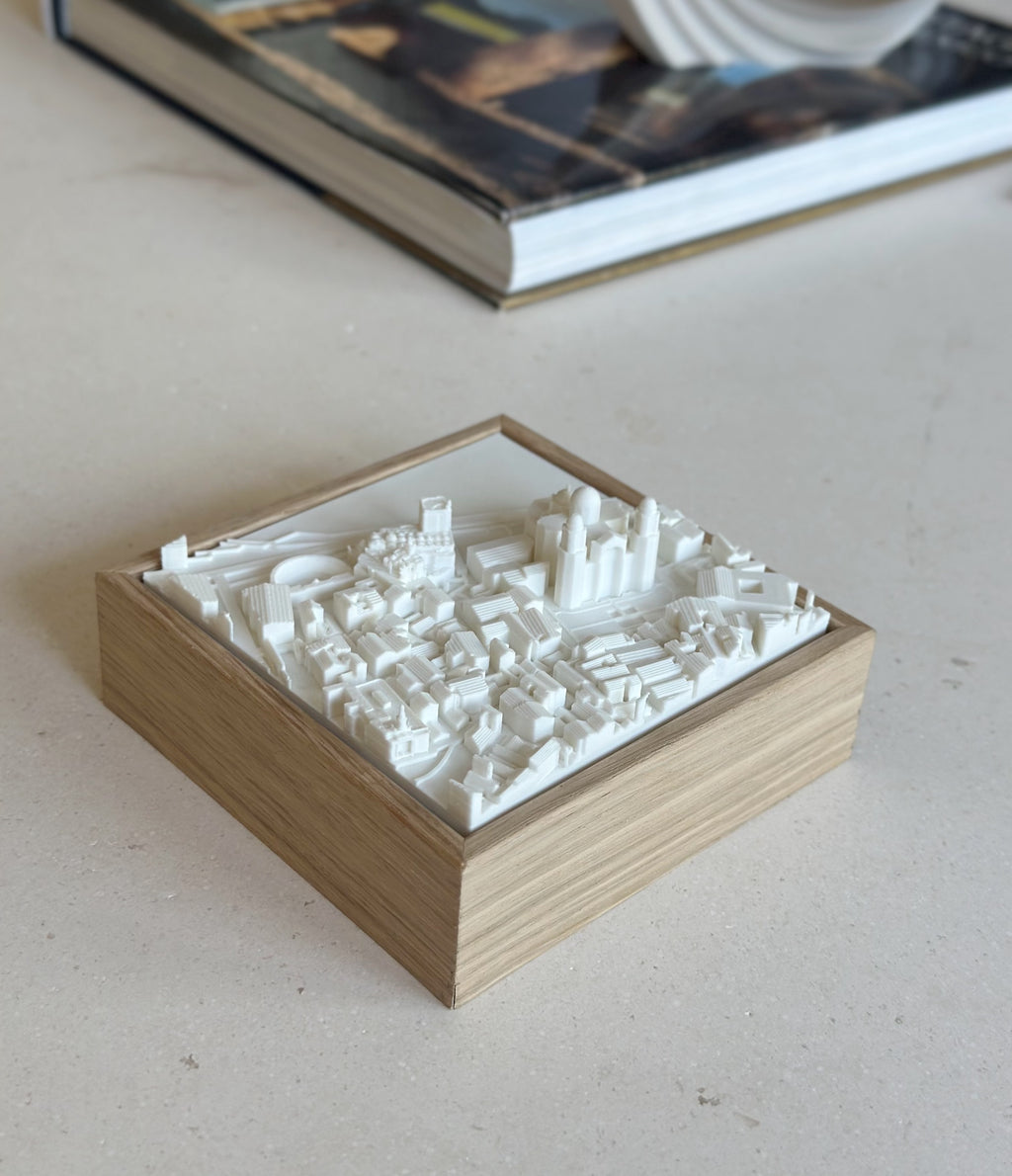 3D city map art in a wooden frame, decorative cityscape sculpture on a table