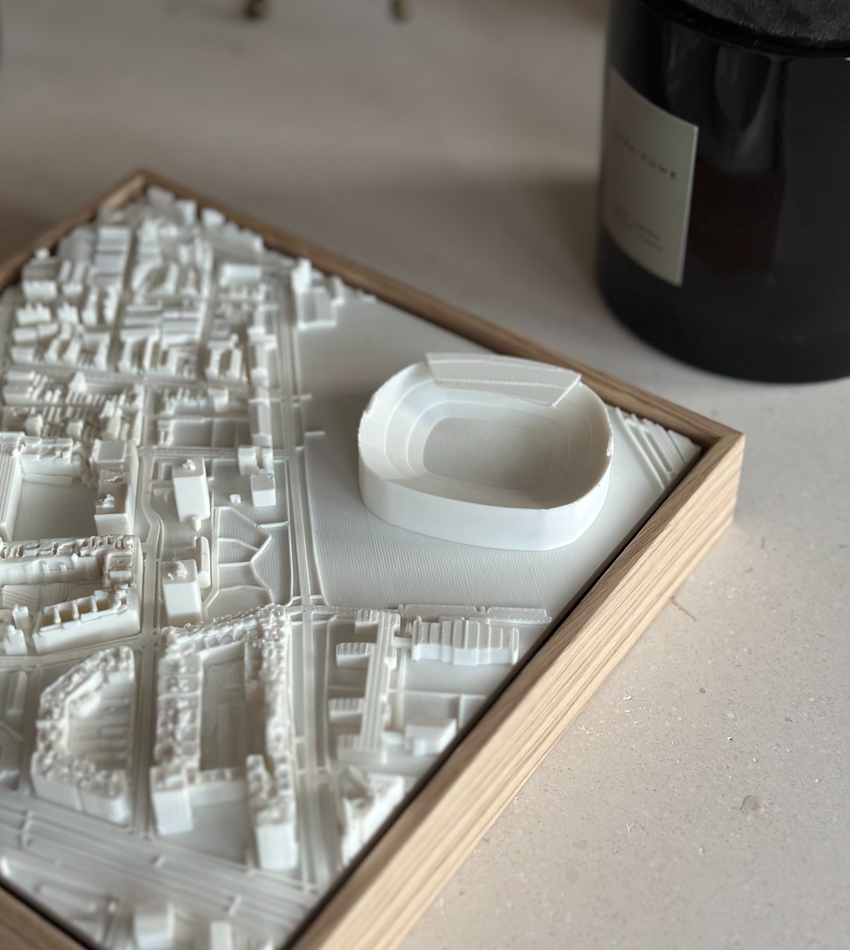 3D city map wall art featuring detailed buildings and a prominent stadium in a wooden frame