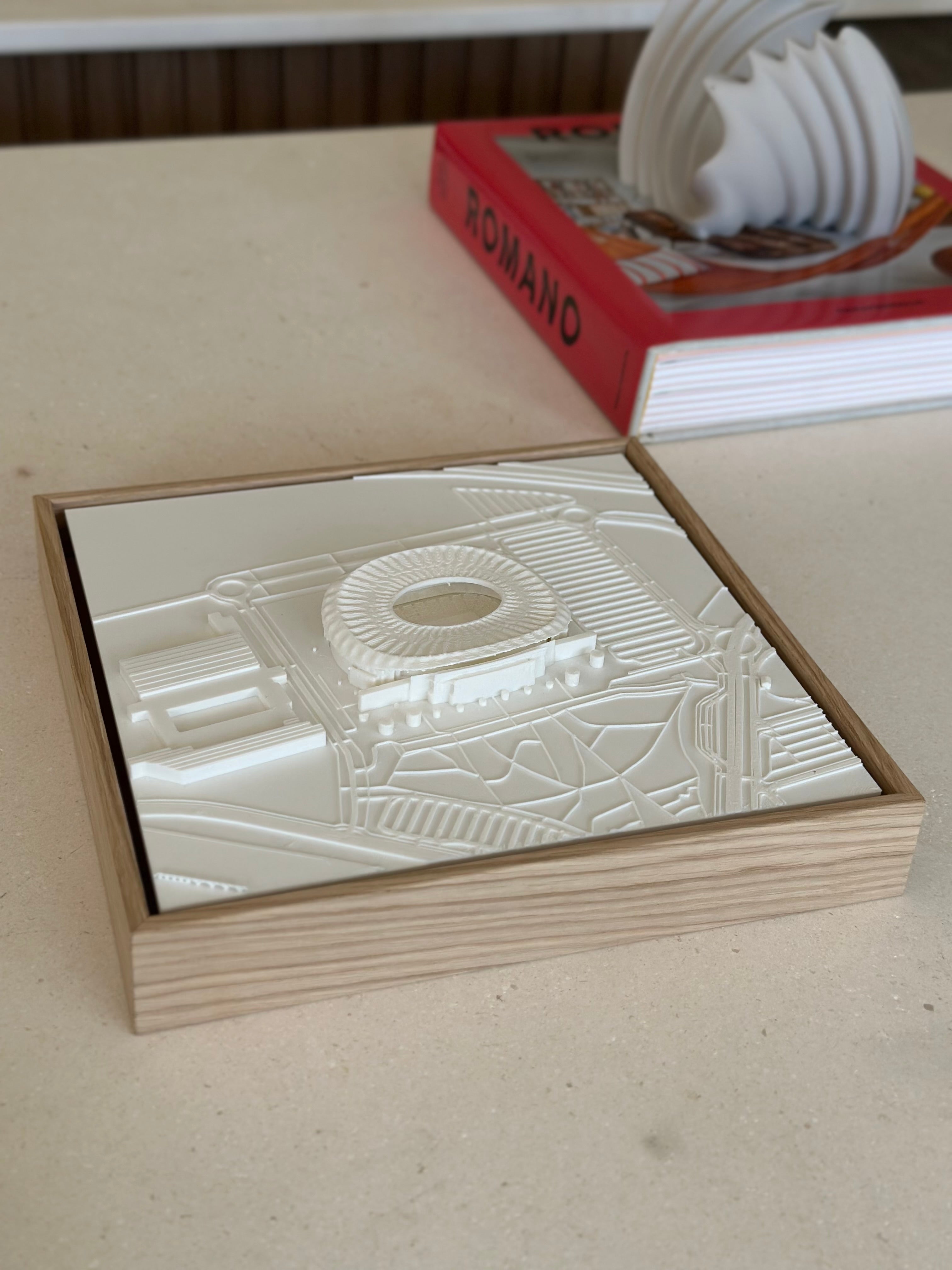 3D city map wall art in a wooden frame on a tabletop, modern urban decor accent.