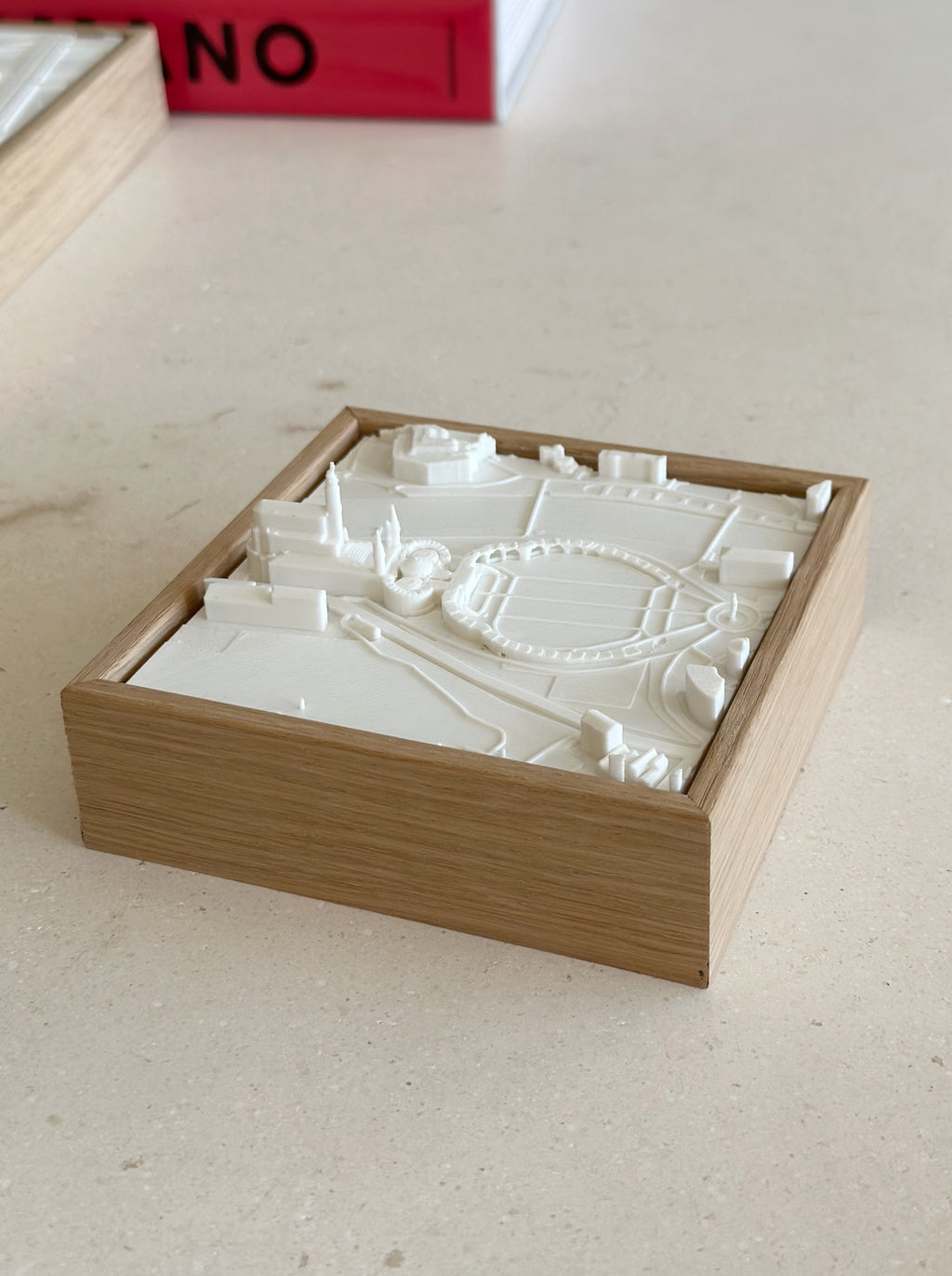 3D city map artwork in a wooden frame on a beige tabletop, decorative home decor