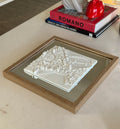 Framed 3D city map art in white, modern home decor on a coffee table with books