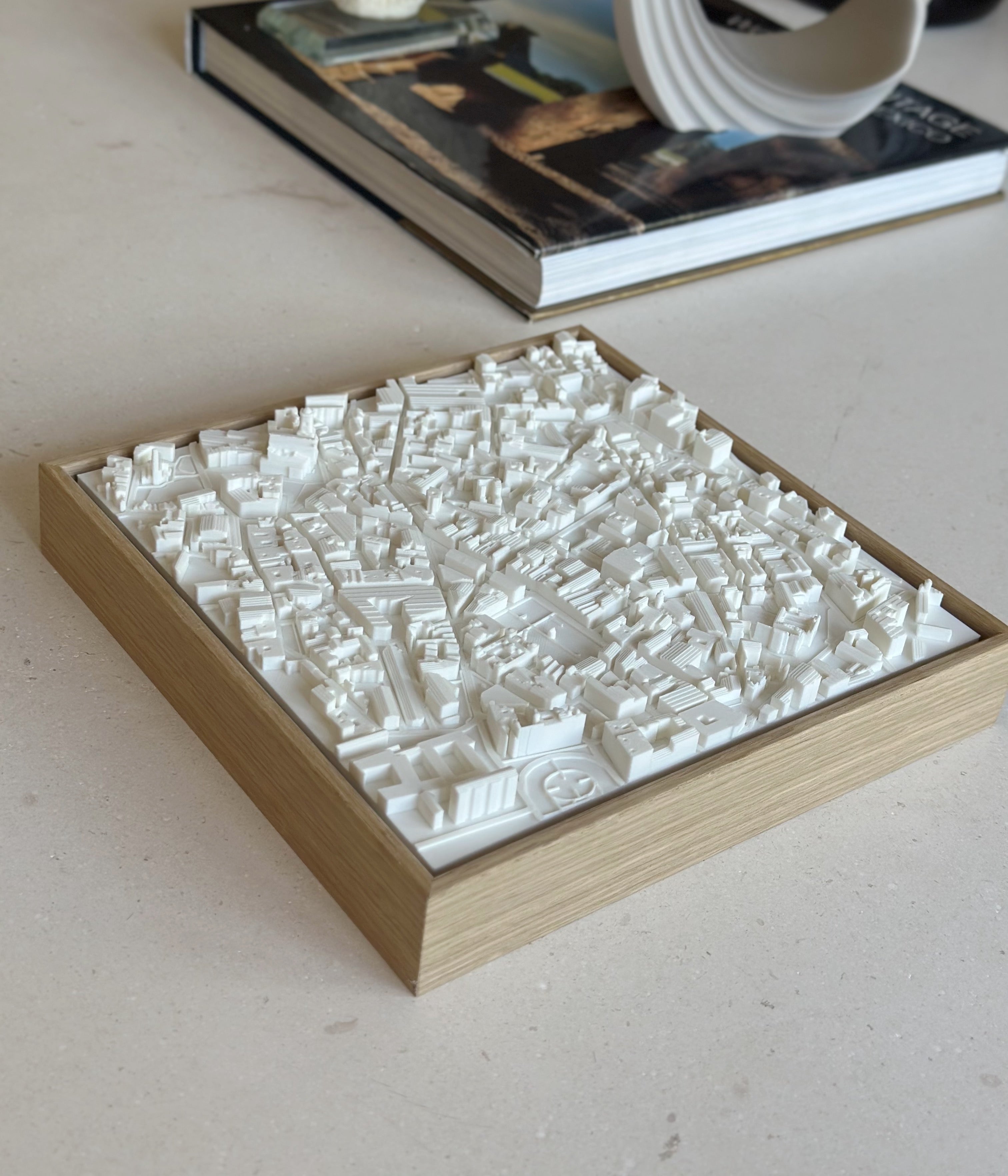 3D city map wall art in a wooden frame on a light surface, modern home decor