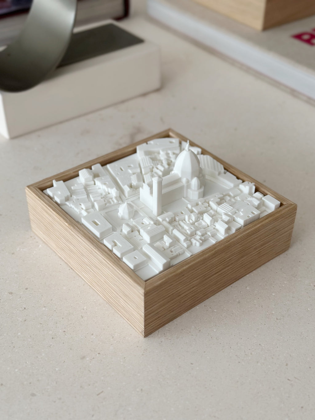 3D city map artwork with white buildings in a wooden frame, decorative tabletop piece