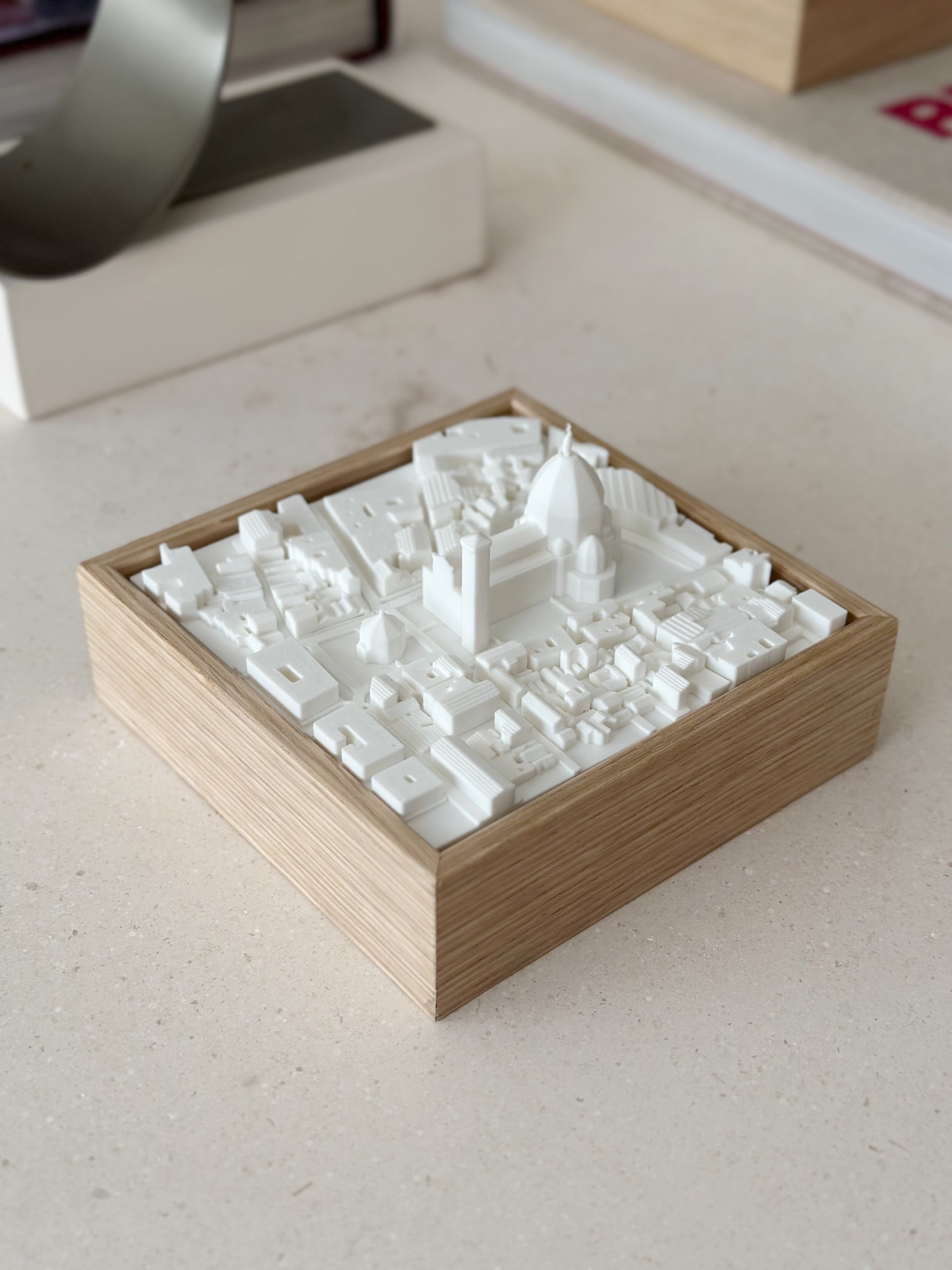 3D city map artwork with white buildings in a wooden frame, decorative tabletop piece