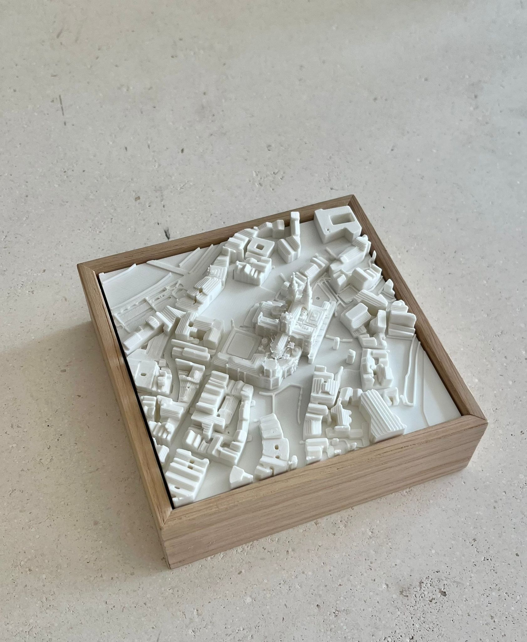 3D city map wall art in a wooden frame, showing detailed urban buildings and streets