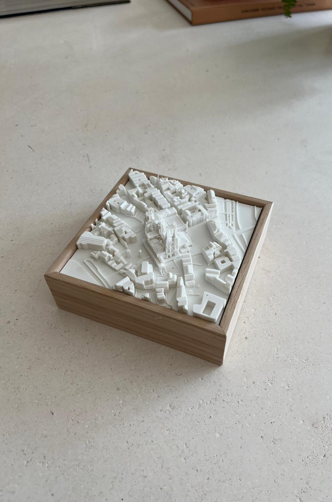 3D city map model in a wooden frame on a light surface, decorative urban art