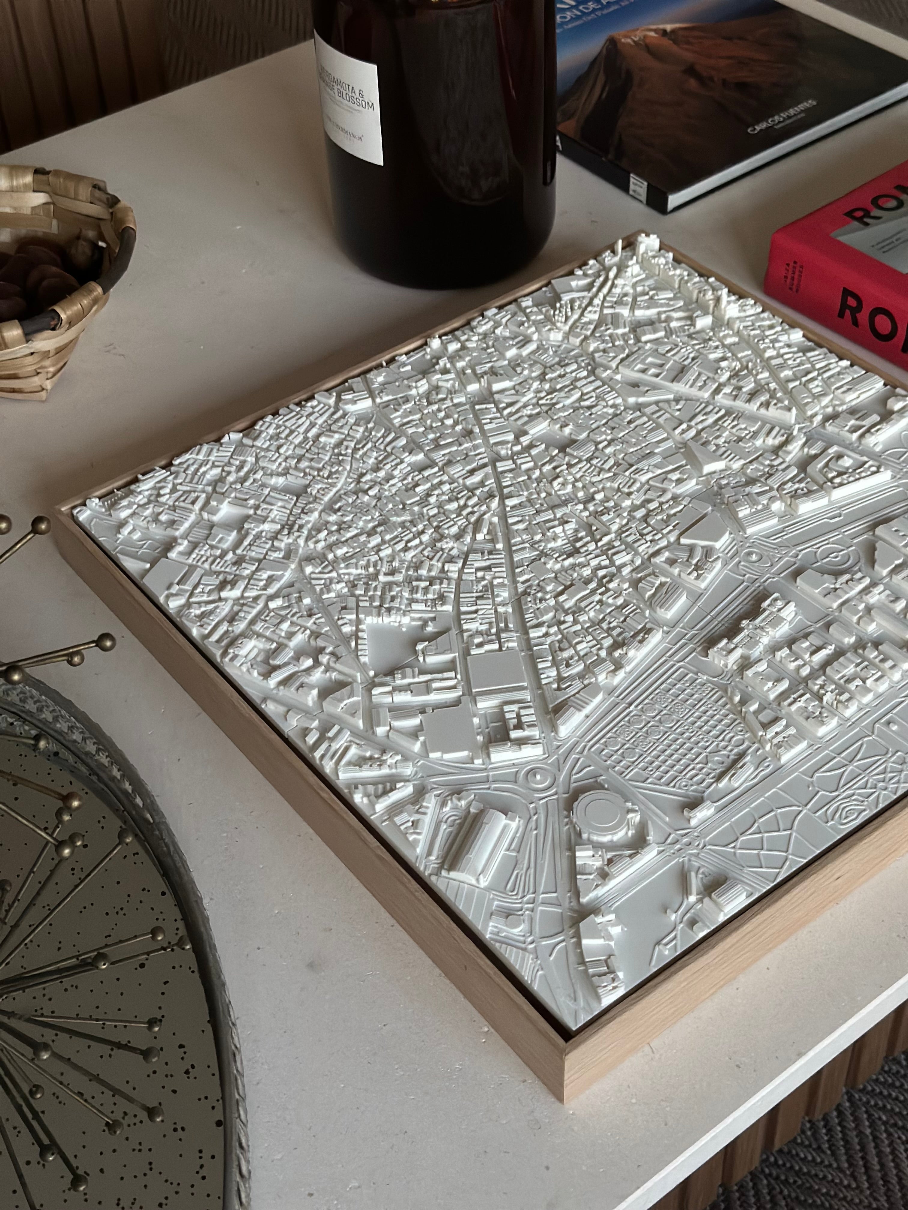 3D city map art piece in white frame on modern coffee table, stylish home décor accent