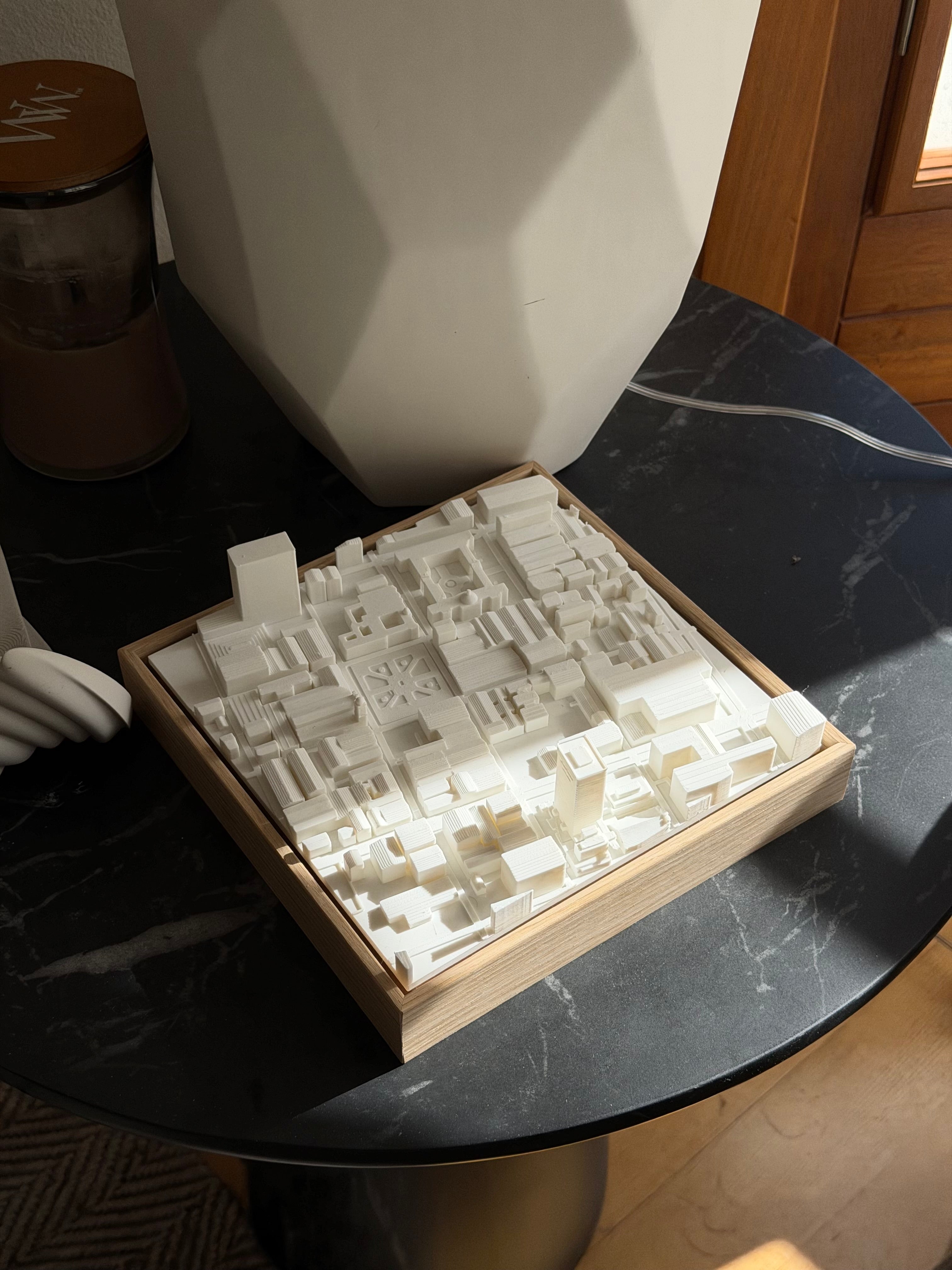 3D city map art in a wooden frame on a black marble table, modern home decor