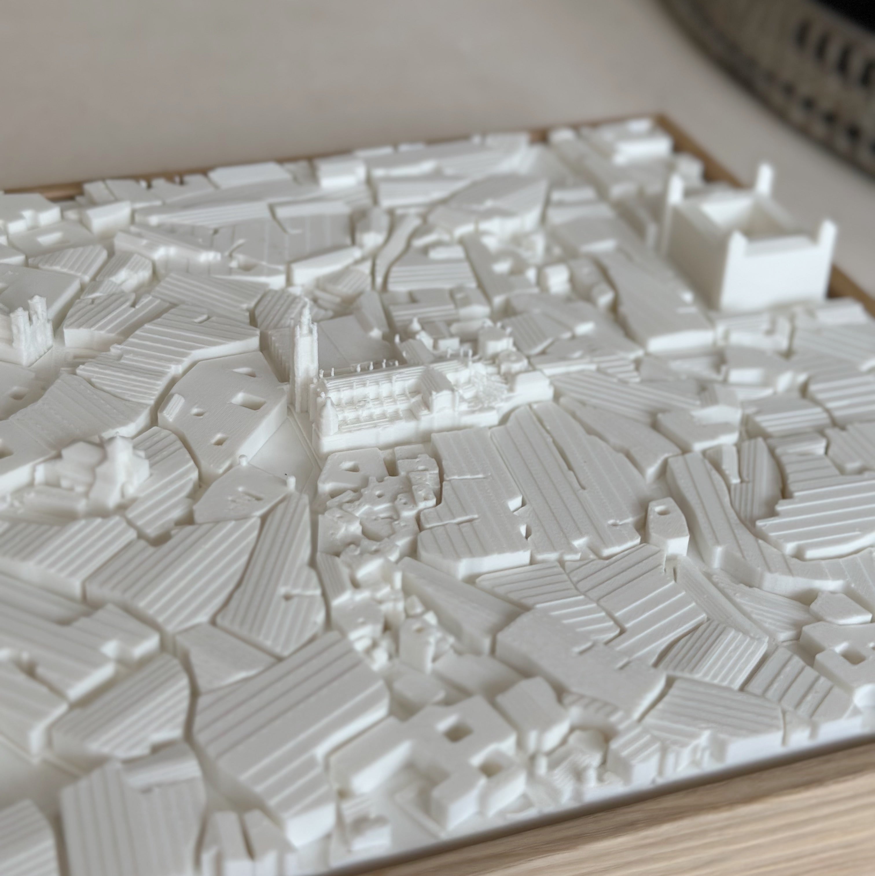 3D city map art in white with raised buildings and streets, decorative wall decor
