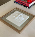 Framed 3D city map artwork with raised white topography on a modern table