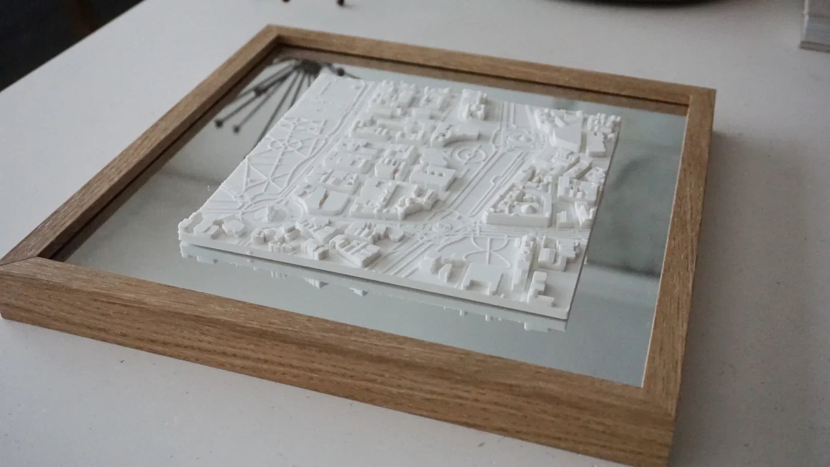 3D city map wall art in a wooden frame, modern home decor on a white table