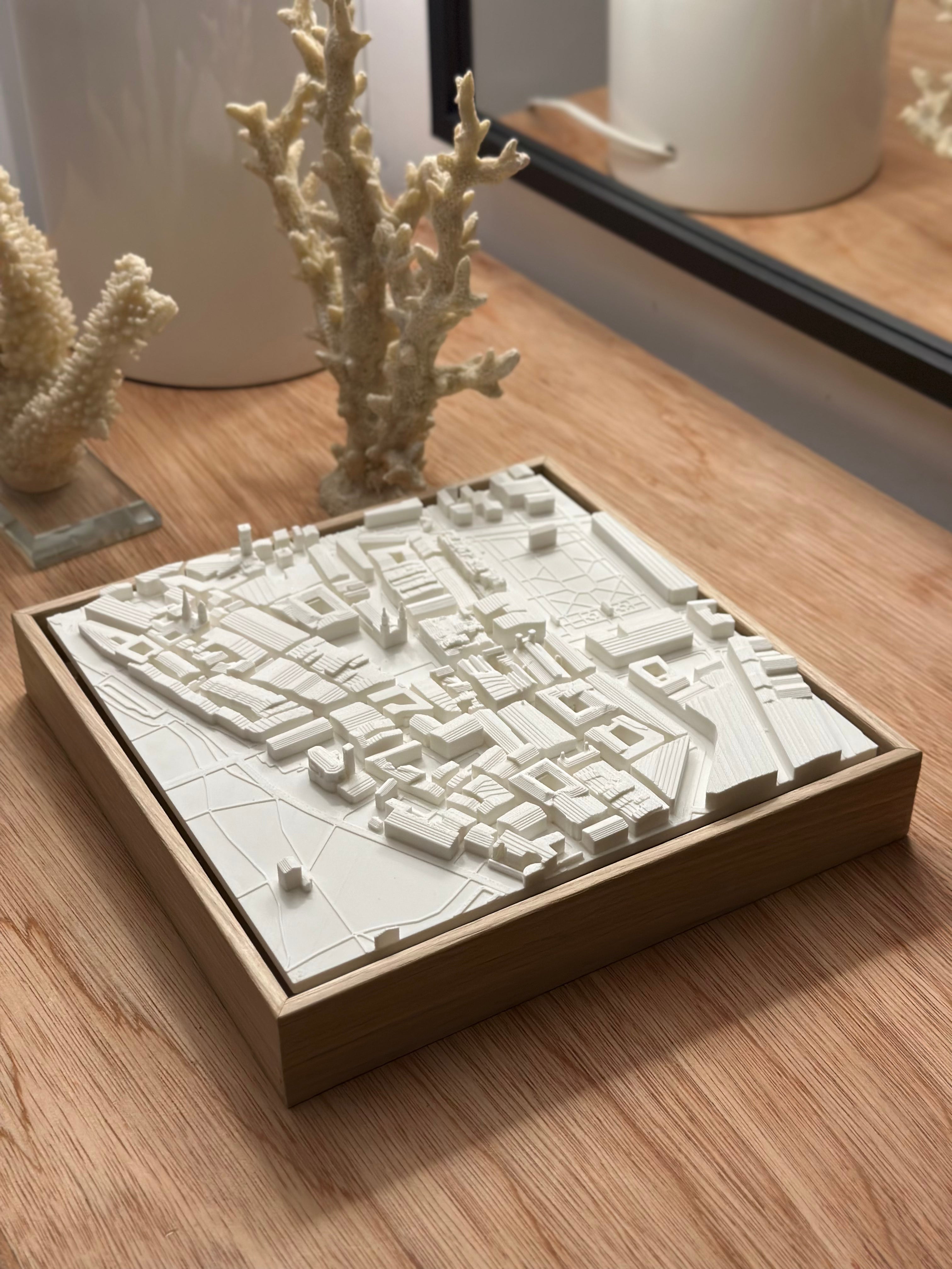 3D city map wall art in a wooden frame on a wooden table, modern decor style
