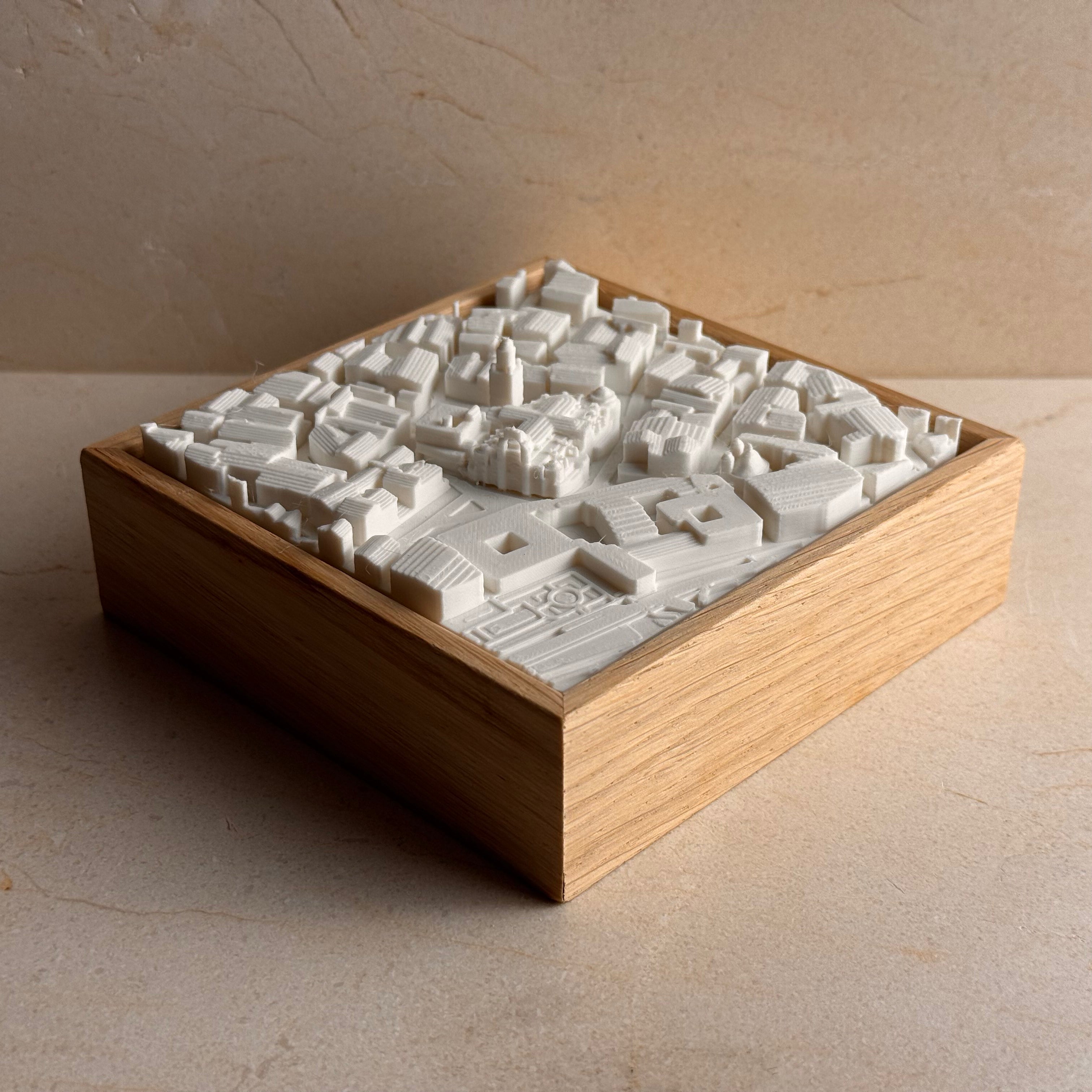 3D city map sculpture in white on a wooden base, modern urban wall art decor