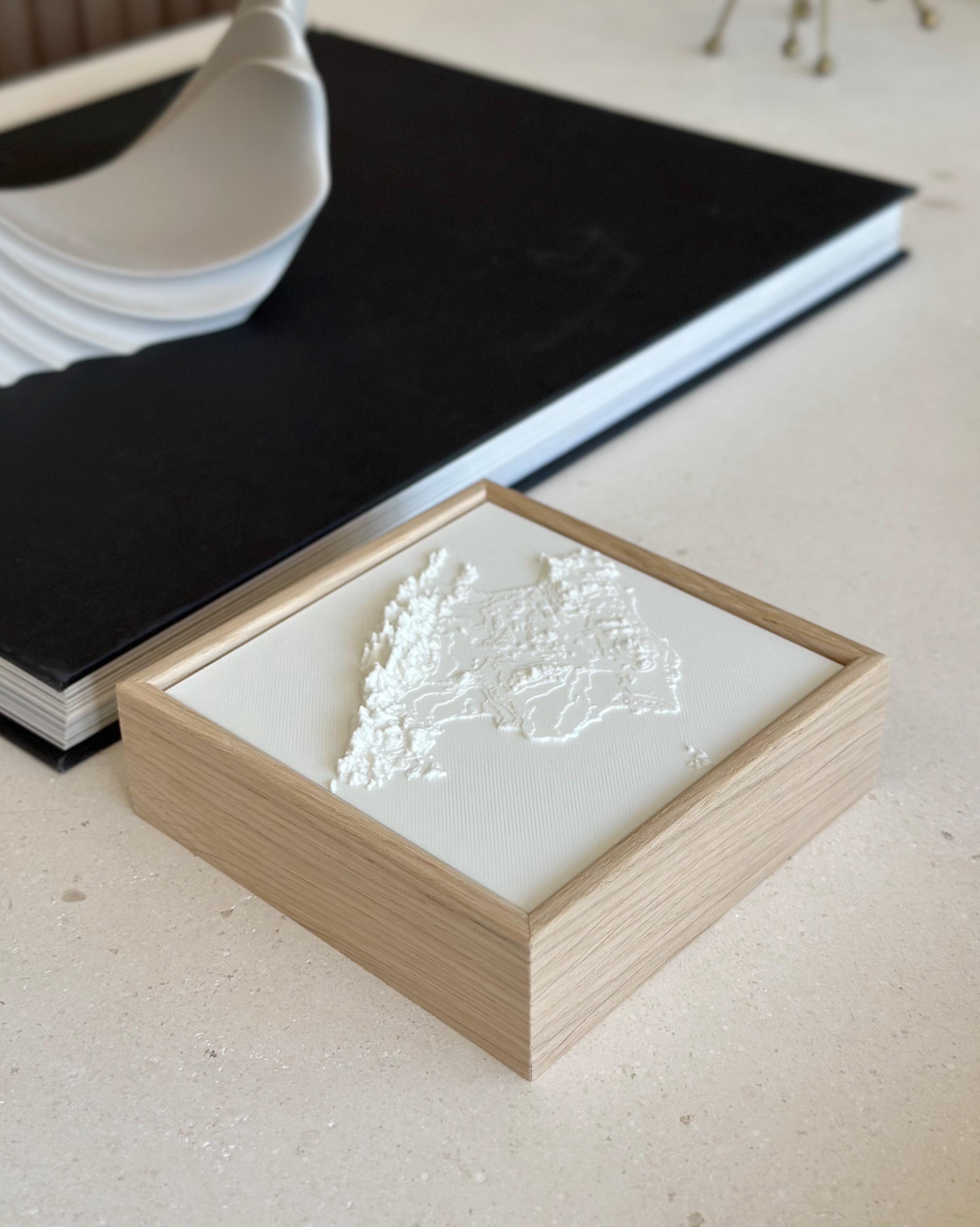 3D city map artwork in a wooden frame on a modern tabletop, decorative wall art